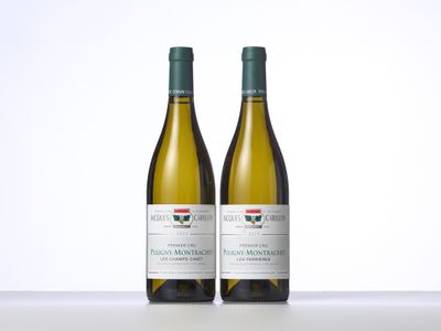 two bottles of white wine sitting on top of a table
