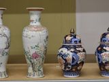 quatre vases exposés sur une étagère dans une vitrine