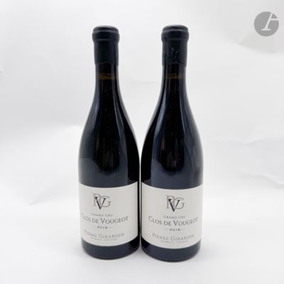 deux bouteilles de vin rouge posées l'une à côté de l'autre sur une surface blanche