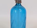 a blue glass bottle with a metal stopper on it