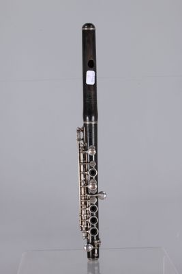 a close up of a silver and black clarinet on a clear surface