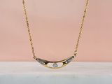 un collier plaqué or orné d'un diamant blanc sur fond rose