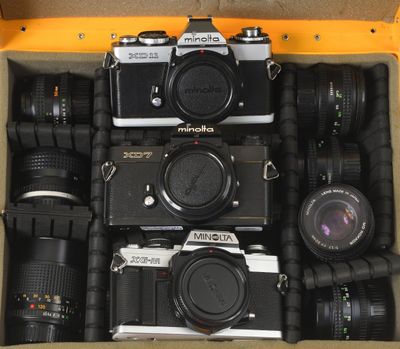 plusieurs appareils photo dans une boîte, posés sur une table
