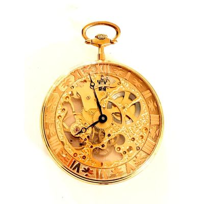 gros plan d'une montre de poche en or sur une surface blanche