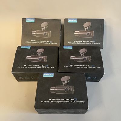 quatre boîtiers noirs d'appareils photo posés sur une table blanche