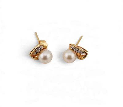 une paire de boucles d'oreilles en perles et diamants sur fond blanc