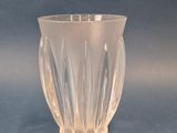 a clear glass vase sitting on a blue surface