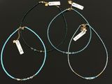 three necklaces with turquoise and gold beads on a black background