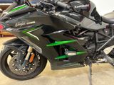 a black and green motorcycle parked in a garage