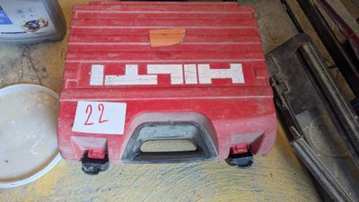une boîte à outils rouge posée par terre à côté d'un bol blanc
