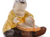 a figurine of a woman sitting on a rock reading a book
