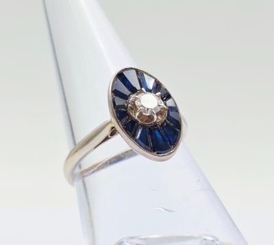 un gros plan d'une bague ornée d'une fleur bleue