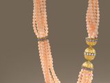 a close up of a necklace with beads on a white surface