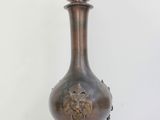 a bronze vase with a lion head on top of it