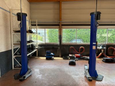 a garage with two blue lifts in the middle of the room