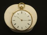 a white clock with roman numerals on it on a black surface