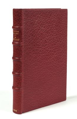 a close up of a book with a red cover on a white surface