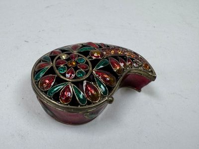 une boîte rouge et verte posée sur une surface blanche