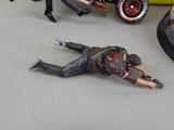 a man laying on the ground next to a toy motorcycle