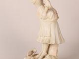 a white statue of a woman holding a child on a rock