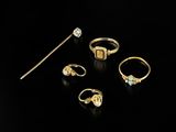 a collection of gold rings and a stick on a black background