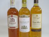 three bottles of wine sitting next to each other on a white surface