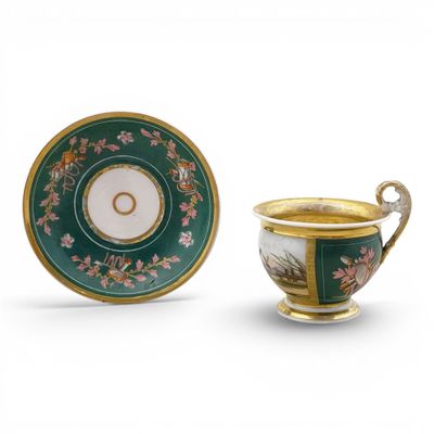 a green and gold cup and saucer with a gold rim