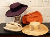 trois chapeaux posés sur une étagère à côté d'un vase