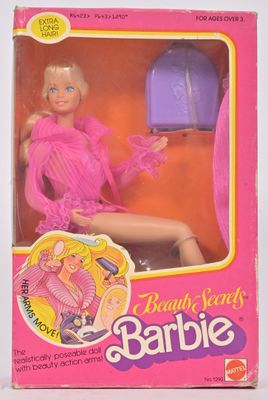 La poupée Barbie se trouve dans une boîte rose avec un sac à main violet.