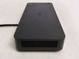 the back of a small black device sitting on top of a white surface
