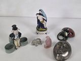 several figurines of people and animals are displayed on a white surface