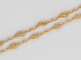 a close up of a pair of gold bracelets on a white surface