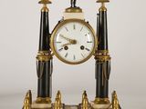 une horloge noire et dorée sur laquelle se tient un homme