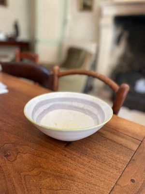 un bol posé sur une table en bois devant une cheminée