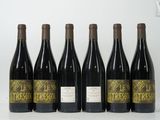 six bouteilles de vin sont alignées sur une table