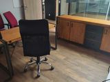 une chaise de bureau noire assise devant un bureau d'ordinateur