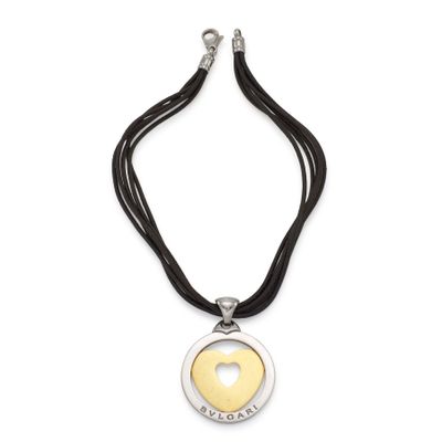 un collier avec un cœur en or suspendu à un cordon noir