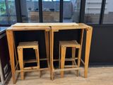 two wooden stools sitting at a table in the middle of a room