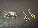 deux paires de boucles d'oreilles en argent et en or posées sur un fond en cuir noir