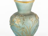 a blue vase with gold decoration on it on a white surface