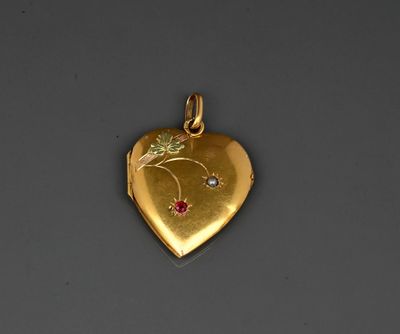 a close up of a gold heart shaped locke with a flower on it