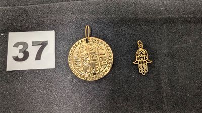 un gros plan sur une pièce d'or et un petit pendentif en or