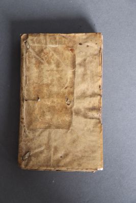 an old book sitting on top of a table covered in brown paper