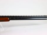 a close up of a rifle on a stand on a white surface