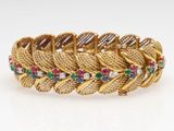 a gold bracelet with multi colored stones