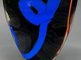 un vase en verre orné d'un motif bleu et rouge
