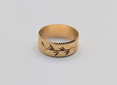 gros plan d'une bague en or sur une surface blanche