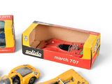 three toy cars in a box on a white surface