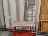 a red ladder leaning against a wall next to a table