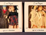 two small dolls in a box on a table